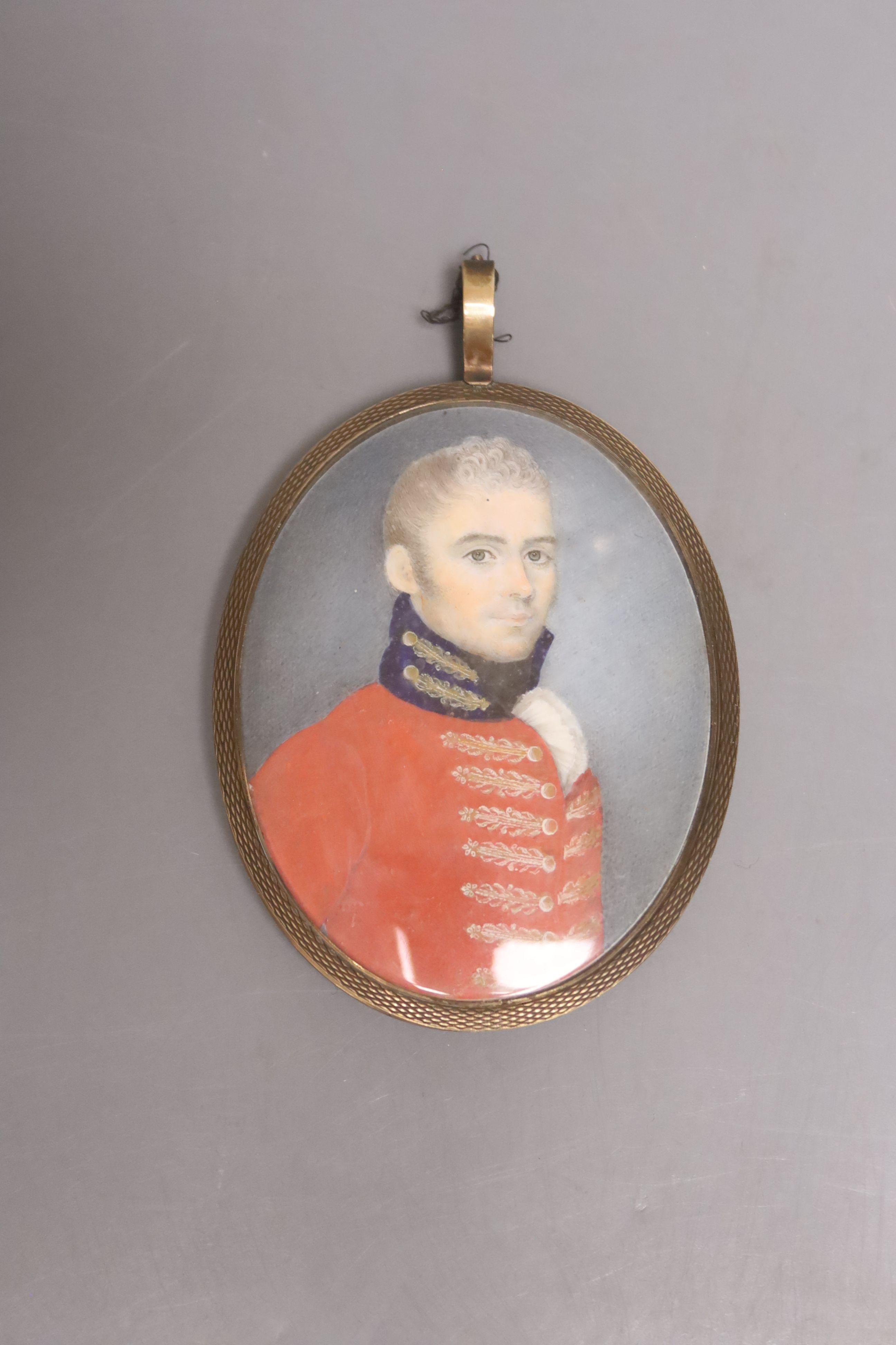 A late 18th century portrait miniature of a military gentleman on ivory, hair and opaline glass back